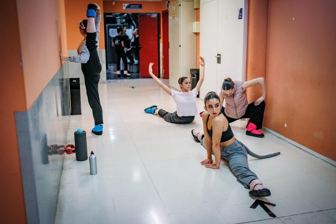 Bailarines calentando en el pasillo antes de la función